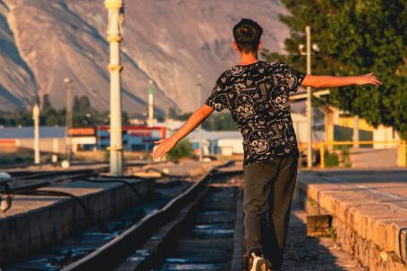 Balance. - Teenage Boy Walking on Railway Tracks
