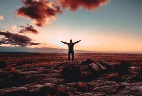 Victory - person standing on rock raising both hands