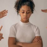 Vulnerable Authenticity - Faceless people scolding discontent black girl