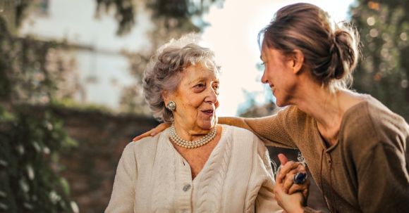 Values-happiness Relationship - Joyful adult daughter greeting happy surprised senior mother in garden