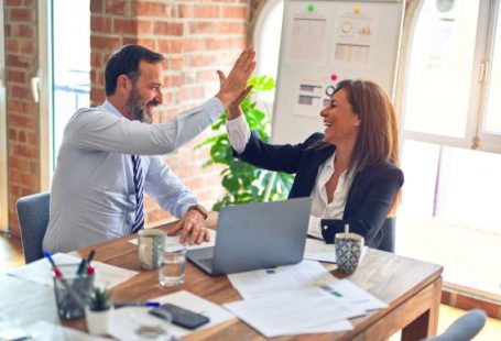 Success - man in white dress shirt sitting beside woman in black long sleeve shirt