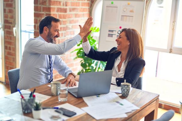 Success - man in white dress shirt sitting beside woman in black long sleeve shirt