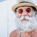 Happy - a man with a white beard and mustache wearing a hat