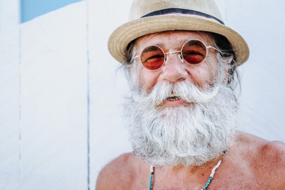 Happy - a man with a white beard and mustache wearing a hat