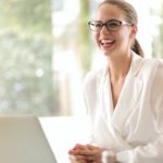 Positive Mindset - Laughing businesswoman working in office with laptop