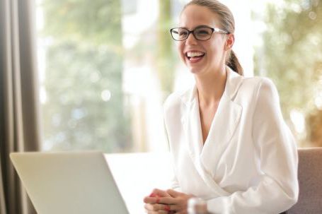 Positive Mindset - Laughing businesswoman working in office with laptop