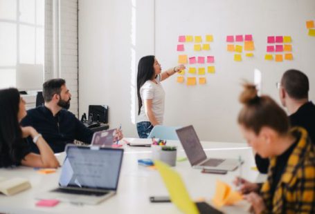 Communication - woman placing sticky notes on wall