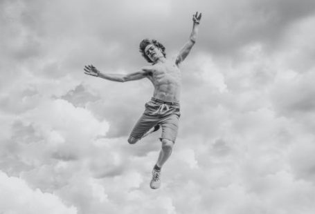 Taking Action. - grayscale photo of person jumping overlooking clouds