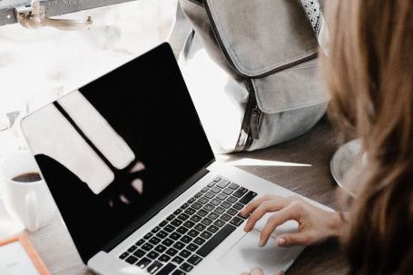 Self-empowerment, Self-compassion - Close-up Photography of Woman Sitting Beside Table While Using Macbook