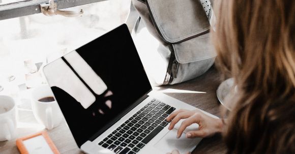 Self-empowerment, Self-compassion - Close-up Photography of Woman Sitting Beside Table While Using Macbook